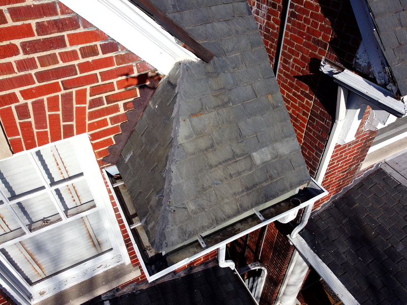 Aerial photo of slate roof feature and downward view of roof gutter.
