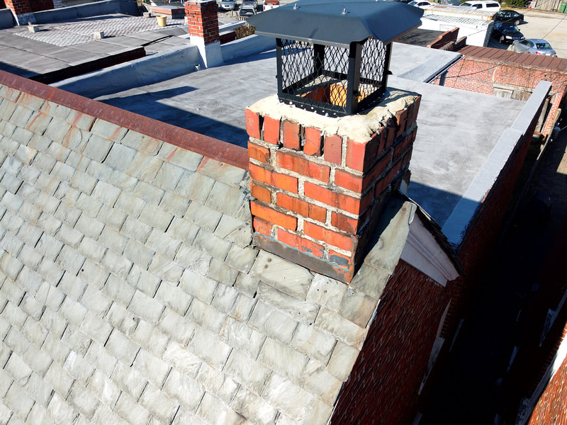 Aerial drone view of a brick chimney on a townhouse.