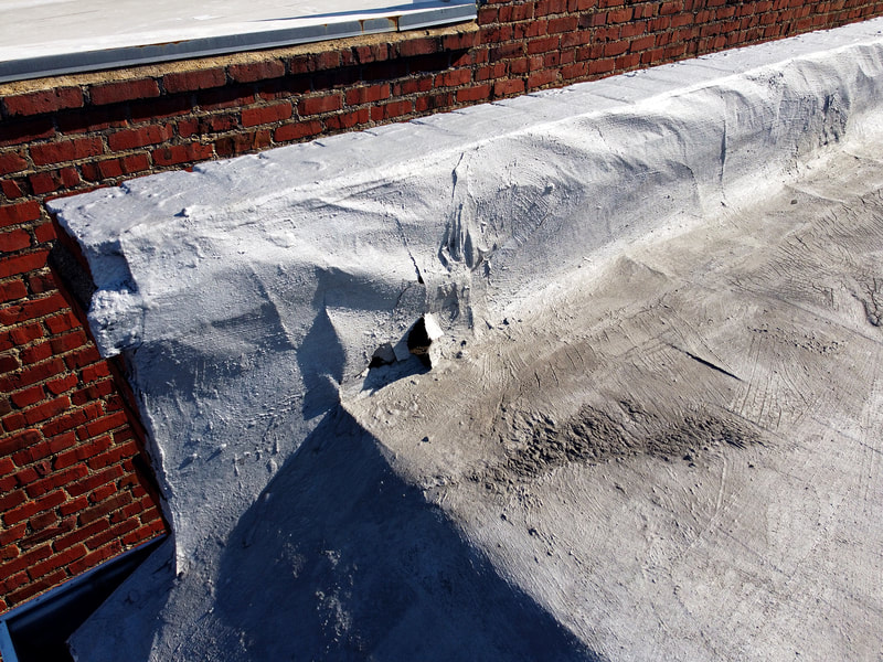 Aerial drone photo of damaged roof membrane on a flat roof.