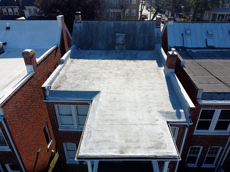 Aerial drone photo viewing the flat roof at the back of a townhouse.