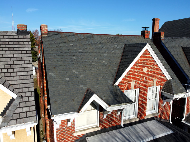 Aerial drone photo of brick town house with slate roof.